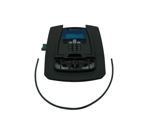 Osłona zestawu robota koszącego AUTOMOWER 315 Husqvarna w kolorze czarnym. Panel górny z czytelnym wyświetlaczem i przyciskami sterującymi. Elementy montażowe w odsłonięte w dolnej części. Produkt leżący płasko na białym tle.