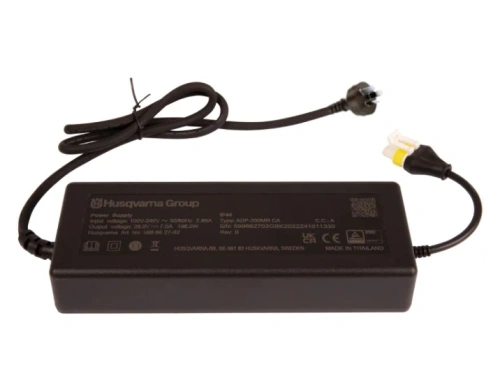 Zasilacz Husqvarna Automower 435X AWD NERA, czarny, prostokątny, z dwiema wtyczkami, widok z góry na tle. Logo Husqvarna i dane techniczne na obudowie. Kabel zasilający z wtyczką sieciową.