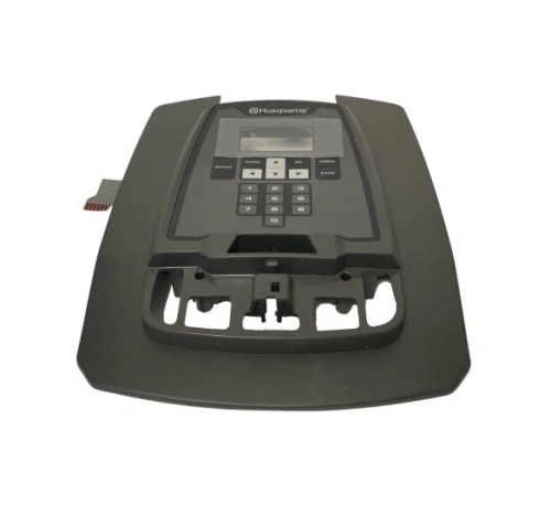 Osłona robota koszącego AUTOMOWER 310 Husqvarna, czarna, prostokątna z zaokrąglonymi rogami. Leży na płaskiej powierzchni, z panelem sterującym i wyświetlaczem oraz złączem kablowym po lewej.