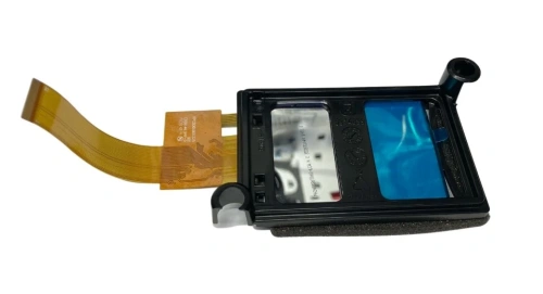 Wyświetlacz robota koszącego Husqvarna AUTOMOWER 435X AWD, widok z boku. Czarne obramowanie z przezroczystym panelem oraz niebieską folią. Widoczne złącze taśmowe. Produkt nie jest zamontowany. Tło białe, proste, co podkreśla detale.