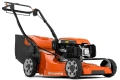 Kosiarka spalinowa Husqvarna LC 353VE w pomarańczowo-czarnym kolorze, z dużymi gumowymi kołami, silnikiem z logo i zbiornikiem na trawę. Ergonomiczne uchwyty gwarantują wygodę pracy.