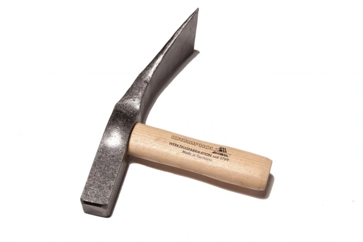 Młotek brukarski 1,5 kg z jesionowym trzonkiem, frontalnie ułożony. Metalowa głowa ma matową teksturę, a drewniany trzonek jest jasny, z widocznymi napisami. Tło białe, co podkreśla szczegóły narzędzia.