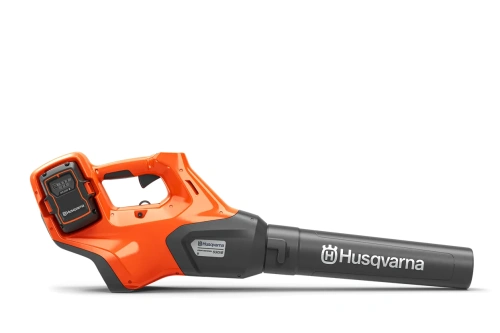 Dmuchawa Husqvarna 530iB w kolorze pomarańczowym i szarym, widok z boku, leżąca poziomo. Wyposażona w ergonomiczny uchwyt z miejscem na akumulator oraz logo Husqvarna na obudowie. Prosty, nowoczesny design z długą rurą do wydmuchiwania liści.