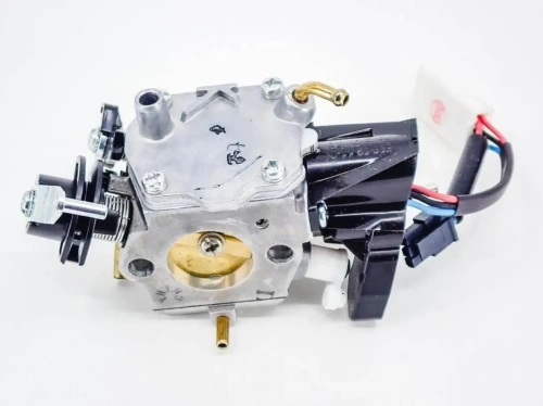 Gaźnik do pilarki Husqvarna 592XP/XPG w metalicznym wykończeniu, z widocznymi elementami mocującymi, rurkami oraz przewodami. Ujęcie z boku ukazuje detale konstrukcyjne i wlot powietrza. Tło białe, co podkreśla szczegóły produktu.