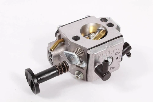 Gaźnik pilarki Husqvarna 543XP/543XPG w kolorze metalicznym, z widocznymi detalami, takimi jak sprężyna i przyciski. Produkt leży na białym tle, zbliżenie ukazuje elementy mocujące i otwór na paliwo.