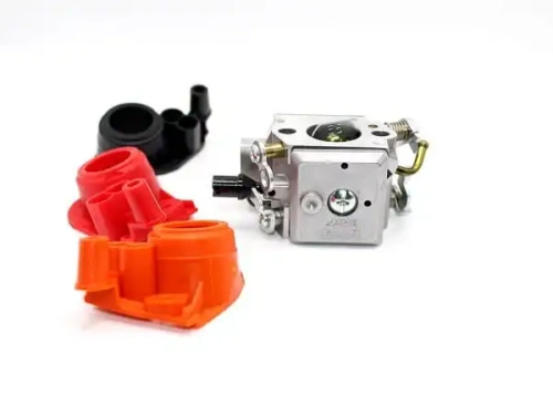 Gaźnik Husqvarna w kolorze srebrnym z dodatkowymi elementami w czerwonym i czarnym kolorze. Widoczny z przodu, z zainstalowaną pompką. W szczególności pokazuje detale, takie jak śruby oraz otwory do podłączeń. Tło białe, co podkreśla produkt.