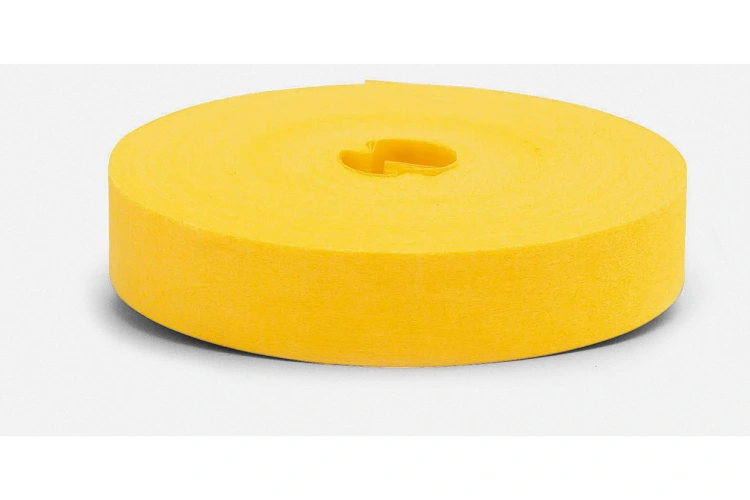 Jednokolorowa taśma do znakowania w intensywnym odcieniu żółtego, nawinięta na okrągły rdzeń. Została pokazana z boku, leżąca na płaskiej powierzchni, z gładką fakturą. Idealna do oznaczenia i organizacji powierzchni.