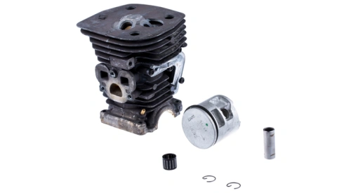 Cylinder pilarki Husqvarna 455 e-series Rancher II z metalowym korpusem w odcieniu szaro-srebrnym. W komplecie tłok, pierścienie oraz niewielki element mocujący. Produkt leży płasko na białym tle, ukazując detale konstrukcji.