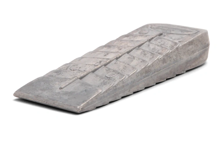 Klin aluminiowy 350g, o prostokątnym kształcie, metalicznym wykończeniu. Widoczne logo HUSQVARNA. Produkt leży na jednolitym tle. Z przodu, spłaszczona końcówka umożliwia łatwe wbijanie. Widoczne oznaczenia na boku ułatwiają identyfikację.