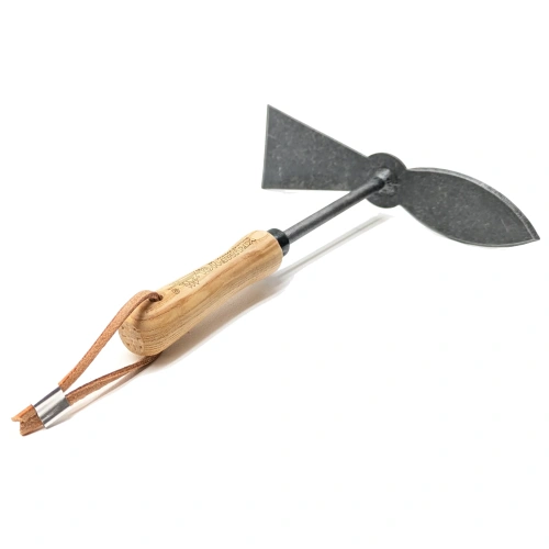 Motyka sercowa Junior z płaskim, z czarnym ostrzem z jednej strony a z drugiej zakończona ostrzem sercowatym osadziem z jasnego jesionu, ujęta z boku, w pozycji leżącej. Proste tło zapewnia wyraźną widoczność detali.