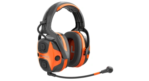 Ochronniki słuchu X-COM Active Husqvarna w kolorze czarnym z pomarańczowymi akcentami. Ujęcie z boku, produkt z widocznym mikrofonem i przyciskami głośności. Wygodne nauszniki idealne do używania na zewnątrz czy w głośnym otoczeniu.