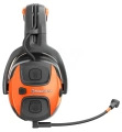 Ochronniki słuchu X-COM Active Husqvarna w kolorze czarnym z pomarańczowymi akcentami. Ujęcie boczne, produkt z widocznym mikrofonem i przyciskami głośności. Wygodne nauszniki idealne do używania na zewnątrz czy w głośnym otoczeniu.