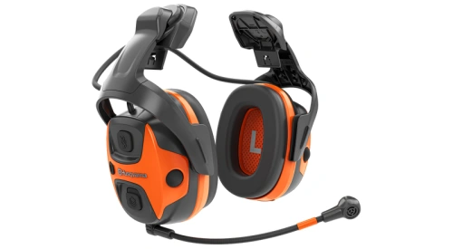 Ochronniki słuchu X-COM Active Husqvarna w kolorze czarnym z pomarańczowymi akcentami. Ujęcie z boku, produkt z widocznym mikrofonem i przyciskami głośności. Wygodne nauszniki idealne do używania na zewnątrz czy w głośnym otoczeniu.