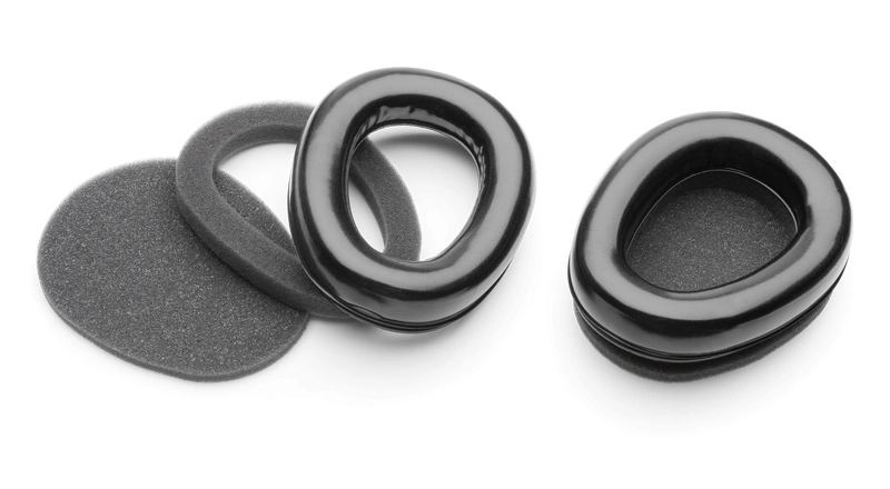 Wymienne wkładki higieniczne do ochronników Husqvarna z radiem FM, z gładką, lekko błyszczącą powierzchnią zewnętrzną, elementy są ułożone luźno obok siebie na jednolitym, jasnym tle