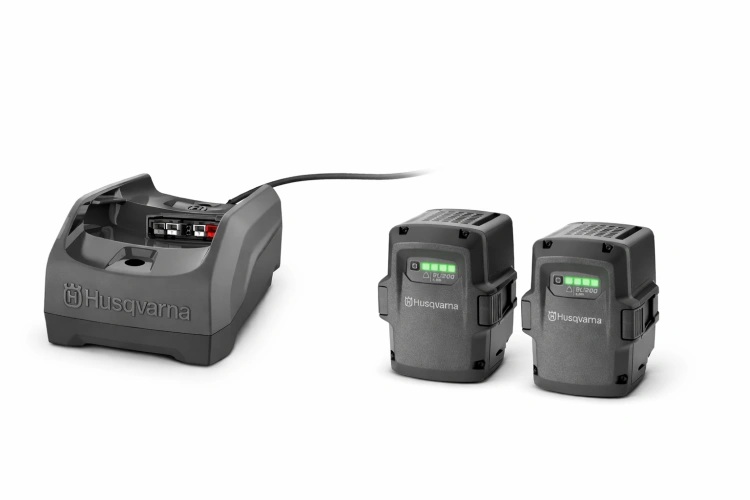 Zestaw akumulatorowy Husqvarna 36V składający się z dwóch akumulatorów litowo-jonowych oraz kompaktowej ładowarki biurkowej 40-C80. Produkt zaprezentowany na białym tle, przeznaczony do profesjonalnych narzędzi akumulatorowych Husqvarna.