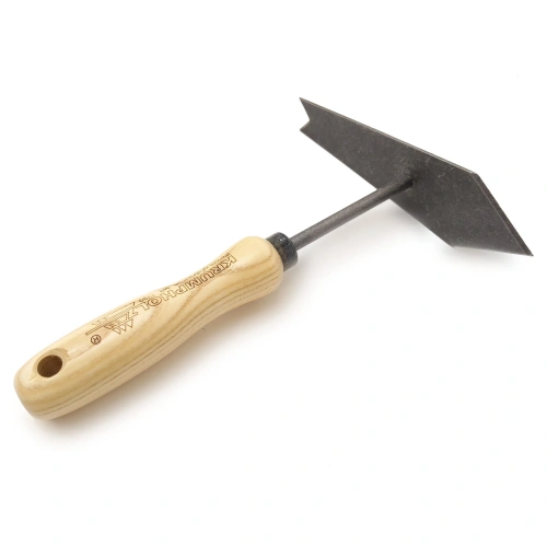 Motyczka do pilenia z płaskim, z czarnym ostrzem z jednej strony a z drugiej zakończona ostrzem sercowatym osadziem z jasnego jesionu, ujęta z boku, w pozycji leżącej. Proste tło zapewnia wyraźną widoczność detali.