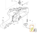 Uszczelka korka paliwa do pilarki Husqvarna 543 XP, w kolorze pomarańczowym, wykonana z gumowanego materiału. Ujęcie z boku, pokazujące detal oraz kształt uszczelki, leżącej na blacie roboczym z widocznymi elementami montażowymi w tle.