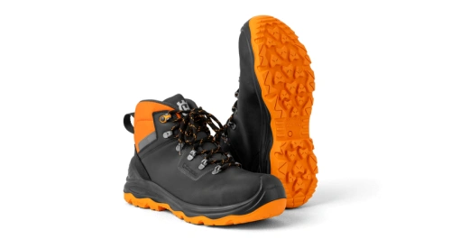 Buty ochronne Technical Light Husqvarna w kolorze czarnym z pomarańczowymi elementami, z metalowymi oczkami na sznurówki. Ujęcie z boku, ukazujące pomarańczową podeszwę z wyraźnym bieżnikiem. Widoczna logo Husqvarna na boku buta.