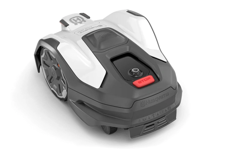 Robot koszący Husqvarna Automower 410VE NERA, biały z czerwonymi akcentami. Widok z przodu z przyciskami start/stop, opływowa obudowa i logo Husqvarna. Prezentowany z poziomu ziemi.