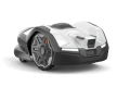 Automower® 405VE NERA to biały robot koszący z charakterystycznym logo Husqvarna, aerodynamicznym kształtem, przyciskiem start i oświetleniem, pokazany z boku na płaskiej powierzchni.