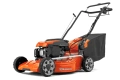 Kosiarka Husqvarna LC 356V w kolorze pomarańczowym, z silnikiem umieszczonym z przodu. Ujęcie z boku, prezentujące złożoną konstrukcję i torby na trawę. Wyraźne logo Husqvarna na korpusie. Gładka powierzchnia, wytrzymałe koła z bieżnikiem.