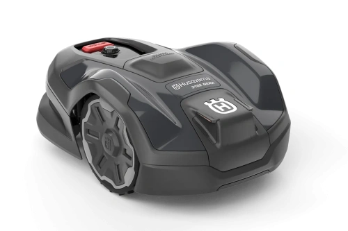 Robot koszący Husqvarna Automower® 310E NERA w kolorze szarym, widok pod kątem, z przodu. Uroku dodaje nowoczesny kształt i logo Husqvarna. Produkt pokazany na jednolitym tle, gotowy do użytku, z wyraźnymi detalami konstrukcyjnymi.