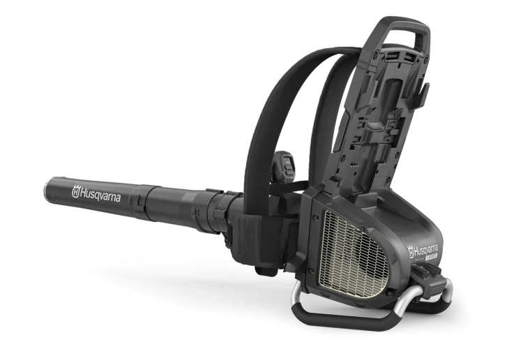 Dmuchawa akumulatorowa Husqvarna 550iBTX w kolorze pomarańczowym z czarnymi elementami, z ergonomiczną rączką i stożkowatym końcem. Produkt ukazany z boku, stoi na płaskiej powierzchni, ze logo Husqvarna oraz napisem modelu widocznym na obudowie.