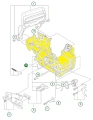 Skrzynia korbowa pilarki 135 Mark II Husqvarna. Zdjęcie ukazujące rysunek techniczny. Karter oznaczony kolorem żółtym, w tle widoczne inne części maszyny.