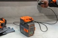Adapter akumulatorowy Husqvarna 40-USB150X w kolorze pomarańczowym, widoczny w komplecie z akumulatorem Husqvarna.