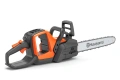 Pilarka akumulatorowa Husqvarna 242i w kolorze pomarańczowym z szarymi elementami, w ujęciu bocznym. Widoczna łańcuchowa układanka z logo Husqvarna, ergonomiczny uchwyt oraz przycisk uruchomienia. Produkt leży na ciemnym tle.