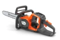Pilarka akumulatorowa Husqvarna 242i w kolorze pomarańczowym z szarymi elementami, w ujęciu bocznym. Widoczna łańcuchowa układanka z logo Husqvarna, ergonomiczny uchwyt oraz przycisk uruchomienia. Produkt leży na ciemnym tle.
