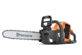 Pilarka akumulatorowa Husqvarna 242i w kolorze pomarańczowym z szarymi detalami, widoczna z boku. Posiada długi, metalowy łańcuch oraz ergonomiczny uchwyt. Na obudowie umieszczone logo Husqvarna. Produkt stoi na stabilnej powierzchni.