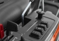 Panel sterujący Rider R 418TsX AWD Husqvarna z boku, czarne przyciski z białymi oznaczeniami, w tym 12 V, metalowa dźwignia z plastikiem, jasne matowe tło.