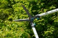 Nożyce do żywopłotu TeleCut Gardena w niebieskim kolorze z pomarańczowym przyciskiem. Metalowe ostrza do precyzyjnego cięcia i ergonomiczny uchwyt zapewniają wygodę użytkowania. Widoczne w użyciu.