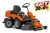 Rider R214C Husqvarna to mały, pomarańczowy traktorek ogrodowy z zestawem tnącym Combi 94 cm. Widok z boku, z siedzeniem, kierownicą i zbiornikiem na trawę. Wysokie koła zapewniają stabilność. Prosta konstrukcja, idealny do koszenia w ogrodzie.