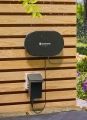 Smart sterownik nawadniania Gardena, w kolorze czarnym, widok zamontowanego na płycie sterownika wraz z ładowarką i przewodami.