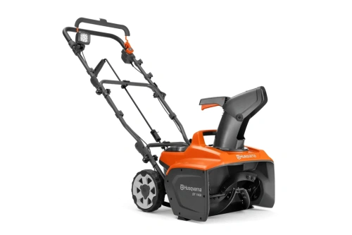Odśnieżarka akumulatorowa ST143i Husqvarna, w kolorze czarno-pomarańczowym, widoczna rura wyrzutowa, koła i wirnik, białe logo Husqvarna na boku maszyny.