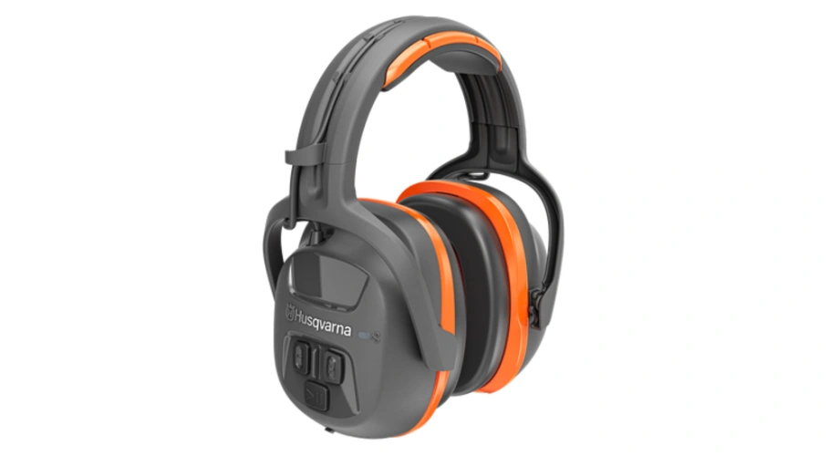 Ochronniki słuchu Bluetooth Husqvarna w kolorze czarnym z pomarańczowymi akcentami. Ujęcie z boku, produkt z widocznymi przyciskami na panelu sterującym. Wygodne nauszniki idealne do używania na zewnątrz czy w głośnym otoczeniu.
