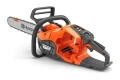 Pilarka akumulatorowa Husqvarna 440i w kolorze pomarańczowym z szarymi elementami, w ujęciu bocznym. Widoczna łańcuchowa układanka z logo Husqvarna, ergonomiczny uchwyt oraz przycisk uruchomienia. Produkt leży na ciemnym tle.
