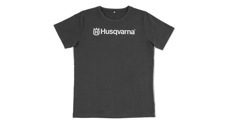 Antracytowy T-shirt z krótkim rękawem, prostym krojem. Na piersi znajduje się wyraźny napis Husqvarna w białym kolorze. Produkt jest prezentowany frontalnie na jednolitym tle, z widocznymi detalami szwów i wykończeń.