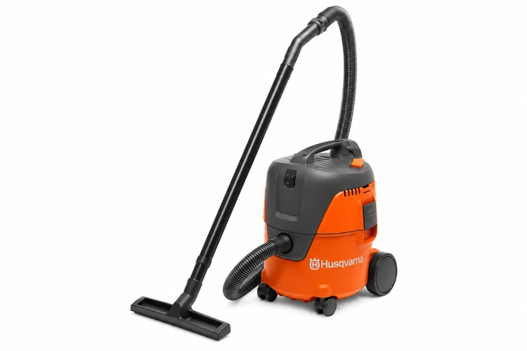 Odkurzacz WDC 220 w kolorze pomarańczowym i szarym, z filtrem, stoi na czterech kółkach. Na zdjęciu widoczna jest rura ssąca oraz ssawka. Produkt ma ergonomiczny uchwyt, a logo Husqvarna jest dobrze widoczne z przodu. Ujęcie frontalne