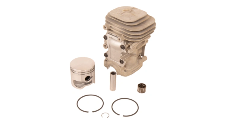 Cylinder pilarki T435 Husqvarna z metalowym korpusem w odcieniu szaro-srebrnym i żeberkami chłodzącymi. W komplecie tłok, pierścienie oraz niewielki element mocujący. Produkt leży płasko na białym tle, ukazując detale konstrukcji.