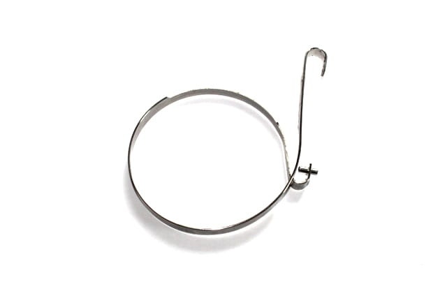 Taśma hamulca pilarki Husqvarna w metalicznym kolorze, o okrągłym kształcie z przymocowanym hakiem. Widoczny element mocujący oraz prosty mechanizm, leżący na białym tle. Idealna do montażu w pilarkach model 251, 254, 262XP.