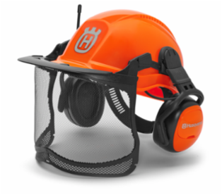 Kask Functional z radiem FM Husqvarna w intensywnym kolorze pomarańczowym. Ujęcie z boku, z ochronnym wizjerem i nausznikami. Widoczne logo na froncie kasku oraz siatkowa osłona twarzy. Kask zamontowany w pozycji na stojąco.